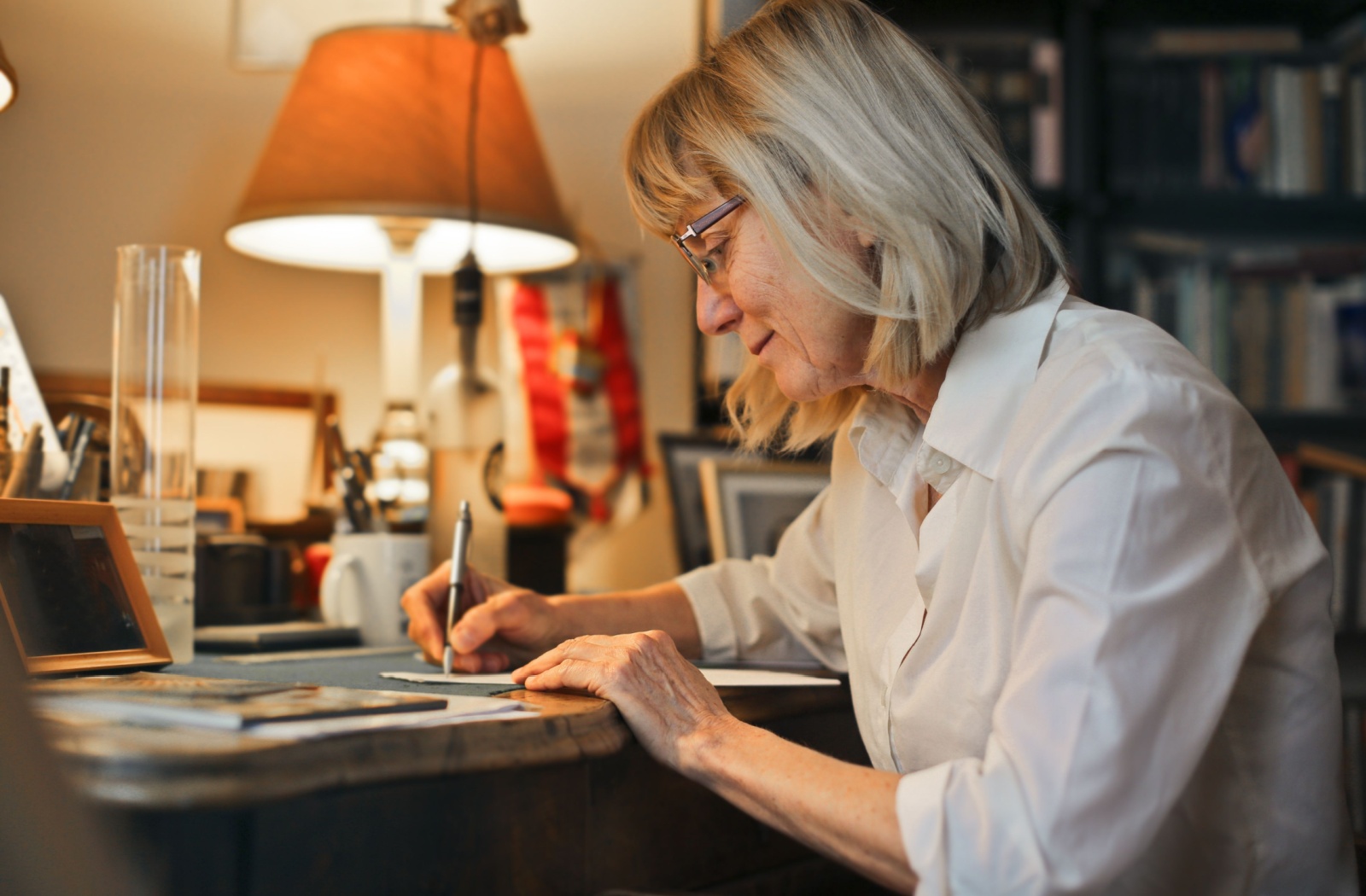 Senior woman writing a letter to her pen pal.
