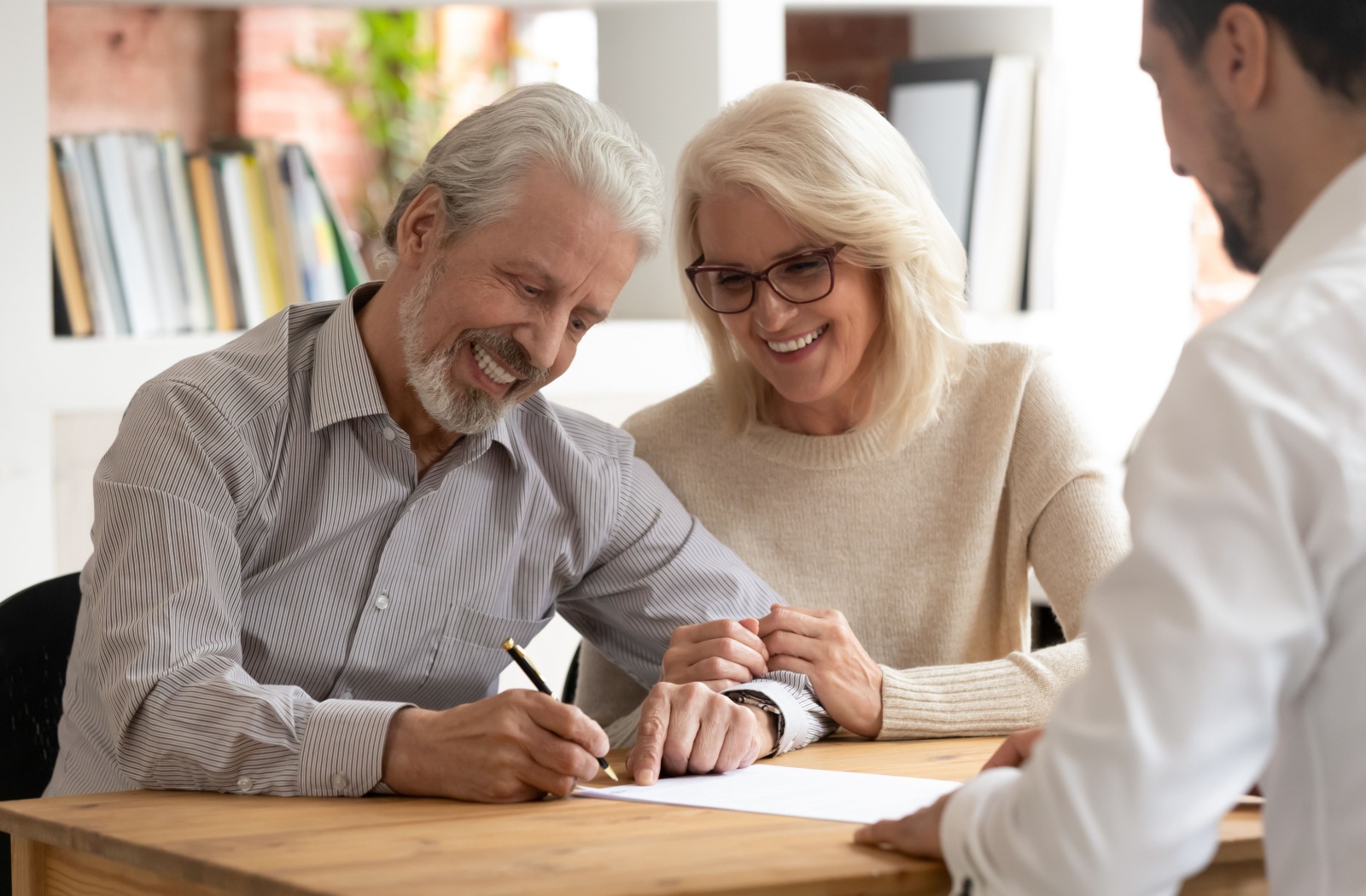 An older couple is signing a legal document.