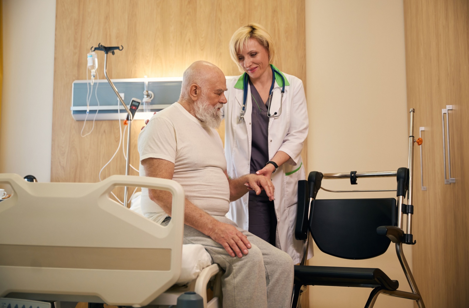 A doctor stands next to a senior recovering from a recent operation.