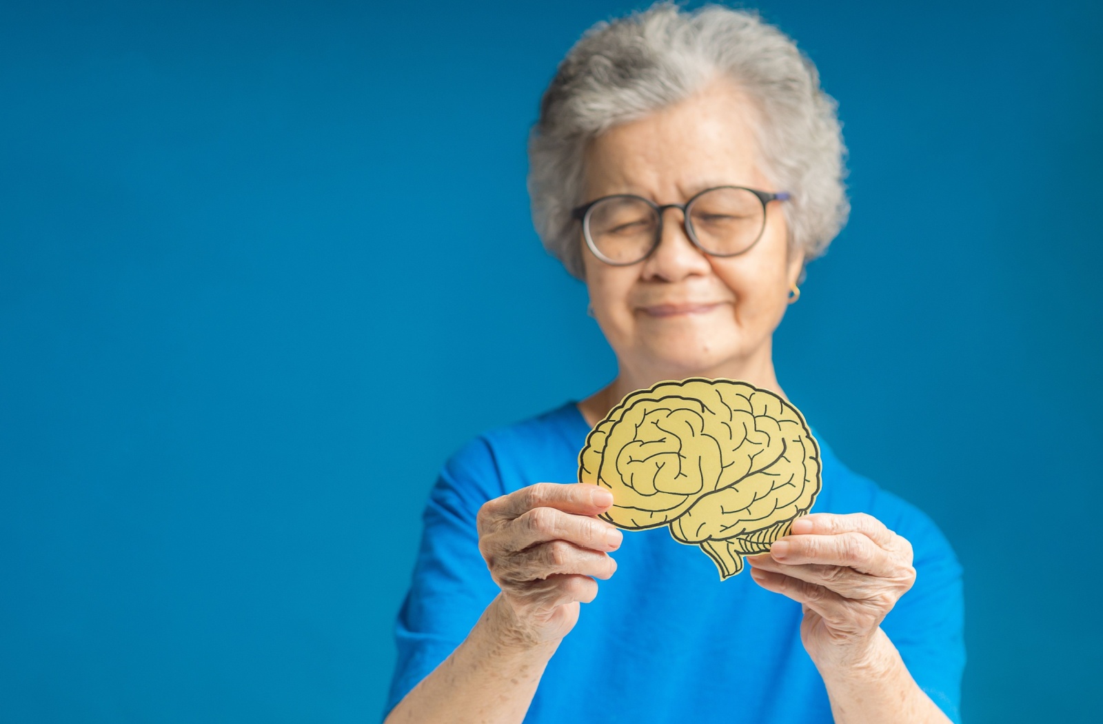 A person is holding a model of a brain to symbolize mental health support after a fall.